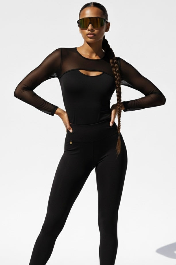 De mesh bij de pas en de mouwen is doorzichtig, het midden dicht. De legging heeft een klein gouden logo.