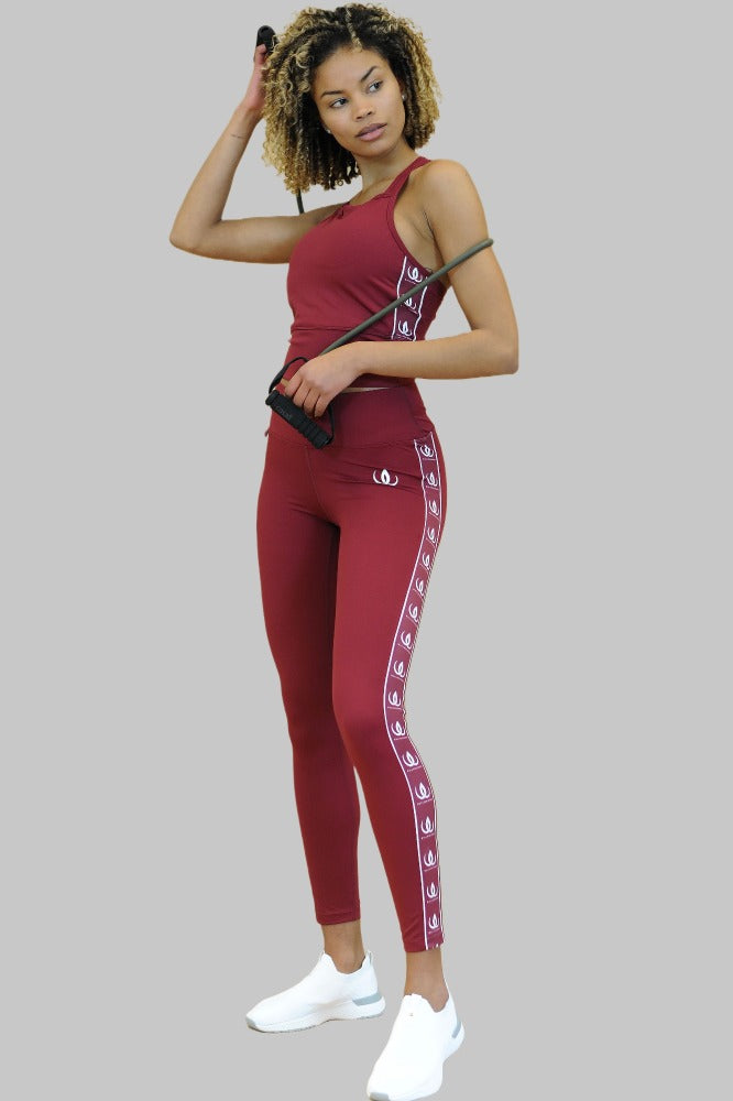 Con una corda per saltare in mano, i leggings bordeaux con un crop top dello stesso colore.