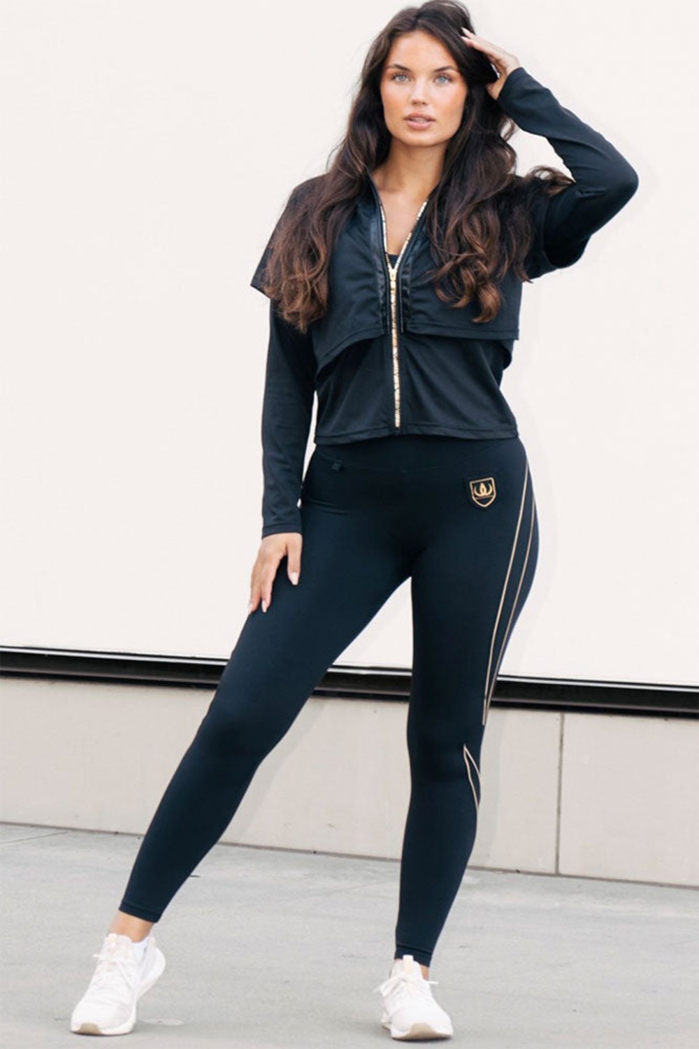 The gold-toned zip runs the full length of the jacket, worn with black leggings with gold lines.