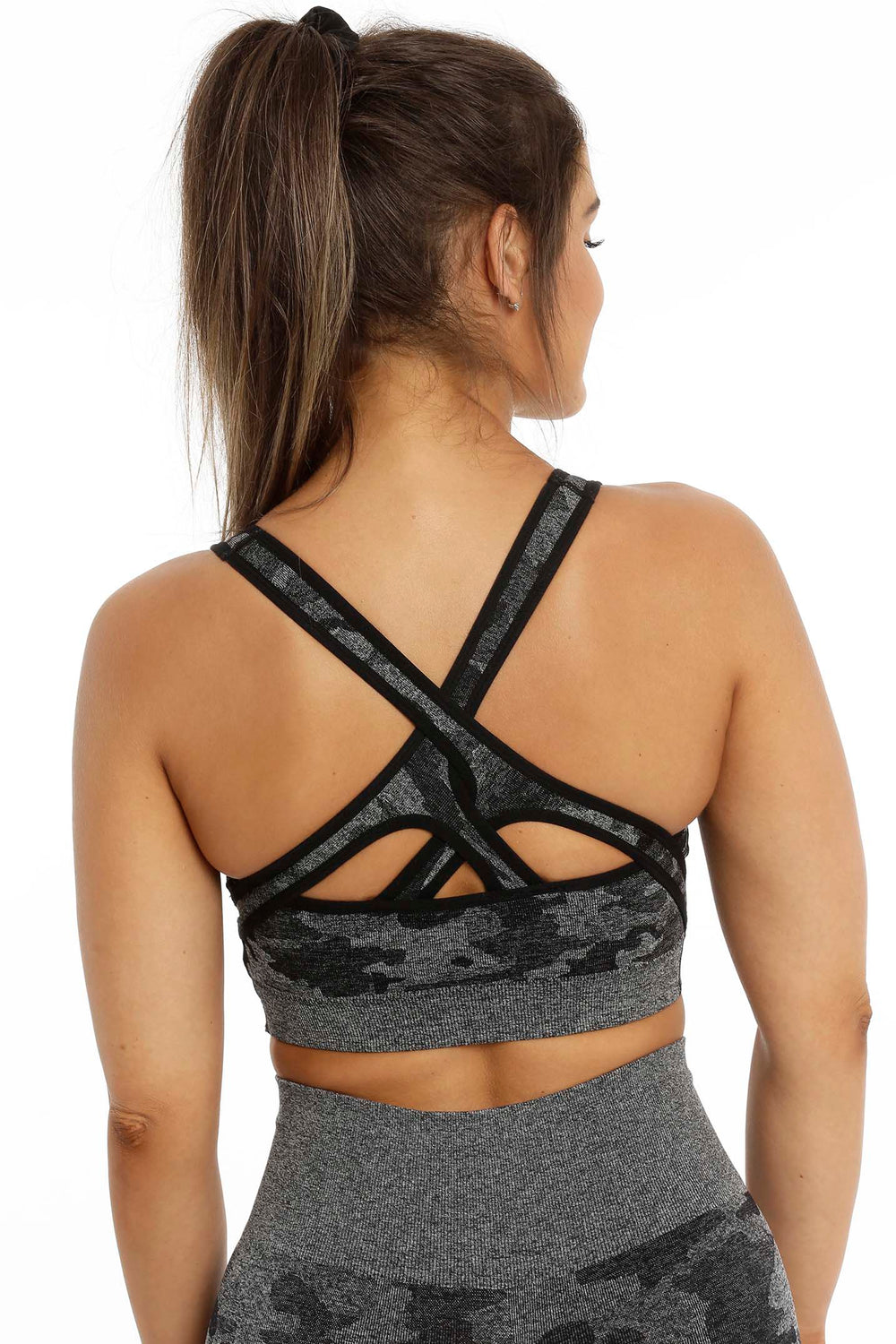 Back of the top with crossed straps and an opening between the shoulder blades, in grey and black camouflage.