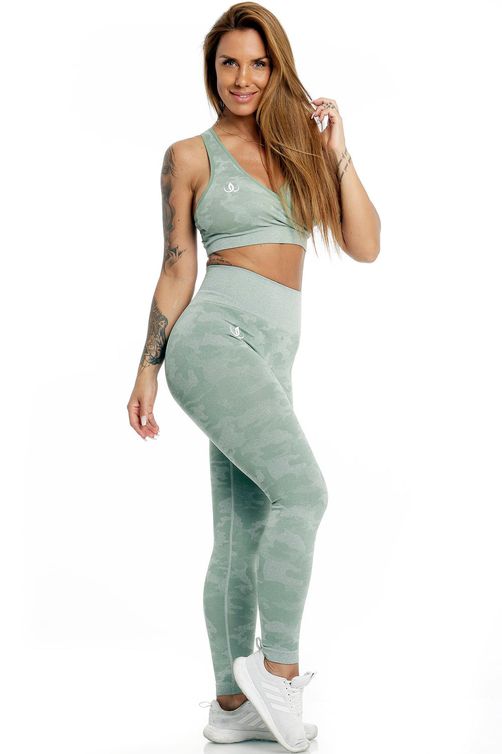 The model stands in the mint green top and camouflage-print leggings, with white shoes.