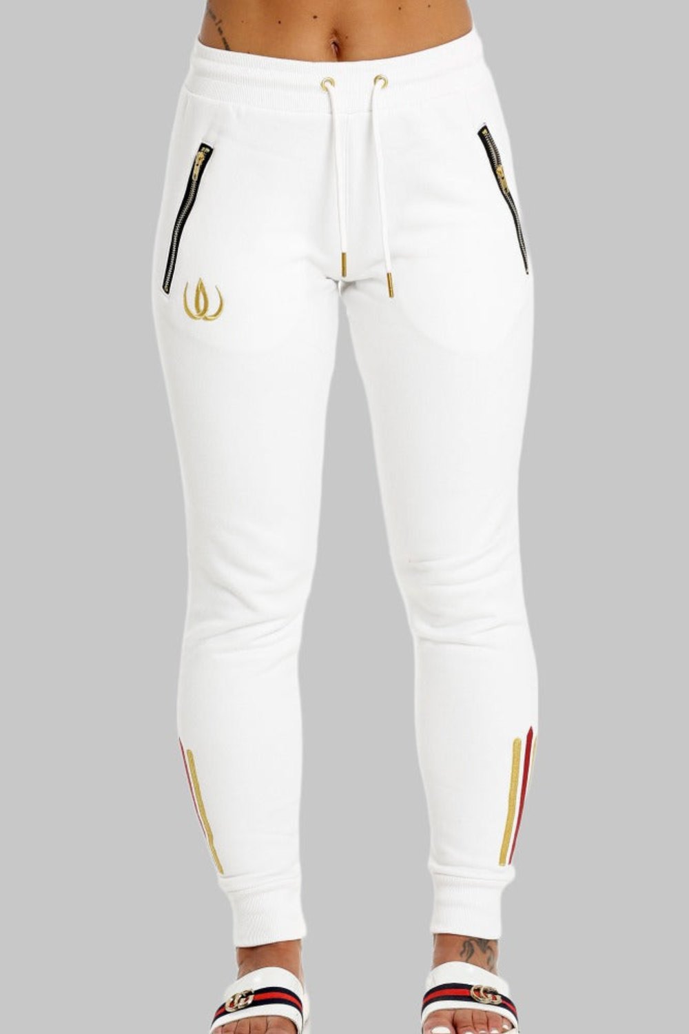 Two gold-toned zip pockets on the white joggers, drawstrings with gold tips and a gold logo on the leg.