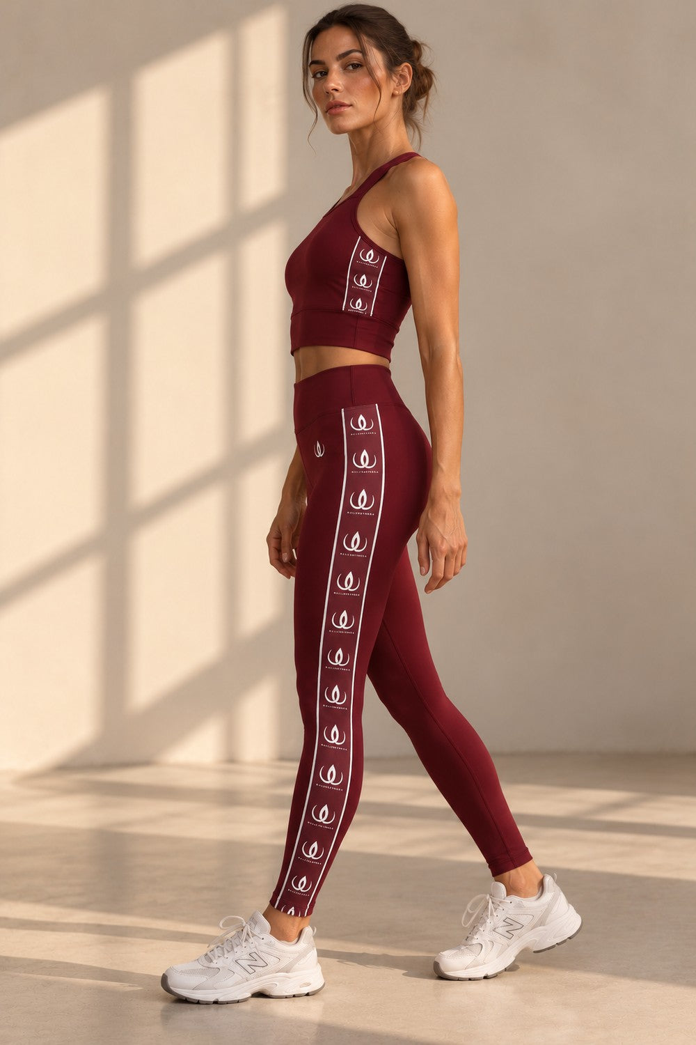 Lux Maroon Träningstights i profil, med loggbandet längs benet och vita sneakers.