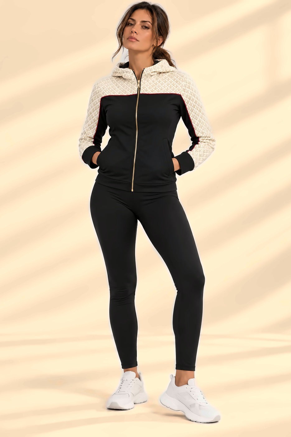 Yoke trainingsjack met een zwarte legging en witte sneakers, volledig beeld in een lichte studio.